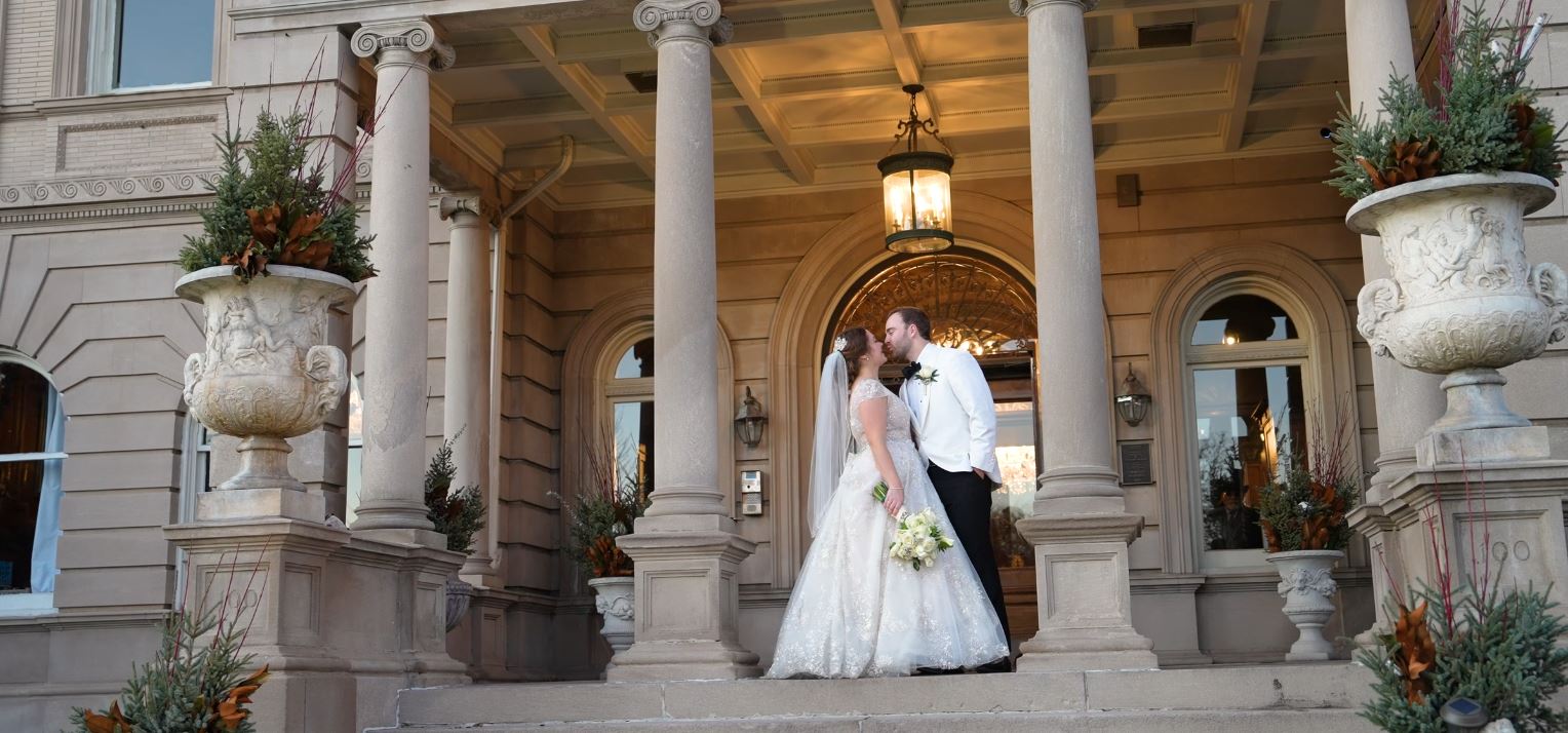 a man and woman kissing in front of a building
